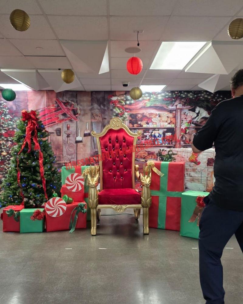 Santa chair photos setup with a gold throne, gift boxes, and a lit tree, empty of Santa