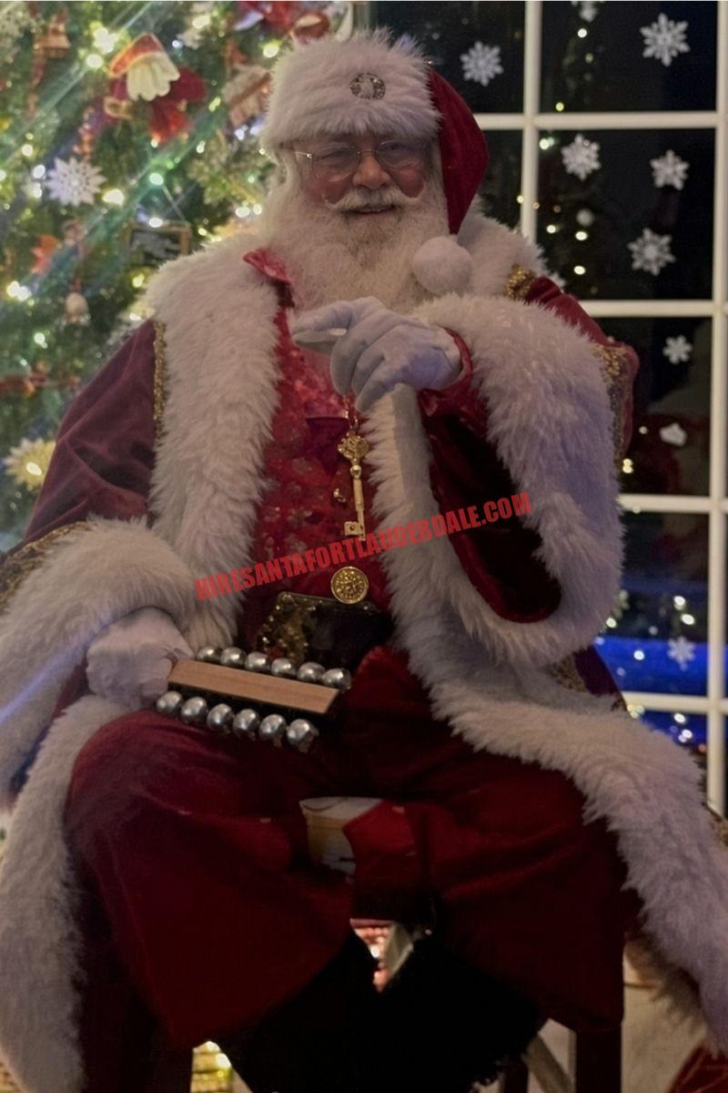 Santa home visit in Coral Springs, FL: Santa seated with sleigh bells by a night window